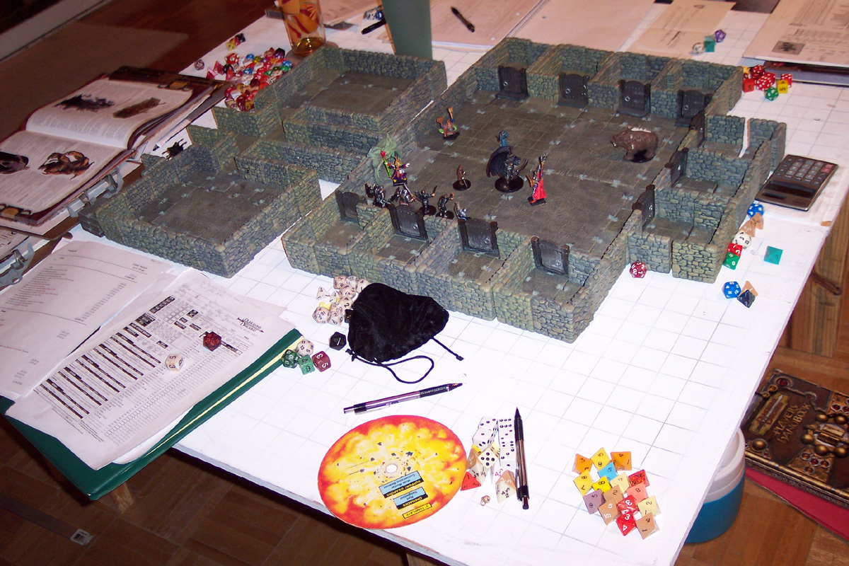 an in-progress D&D game, showing dungeon terrain with character tokens, and lots of papers, pencils, and dice scattered around